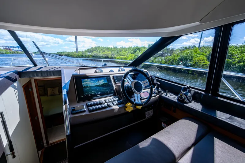 Slide: The Image of Interior view of 2012 Prestige Flybridge yacht cockpit with steering wheel and navigation system. - 52