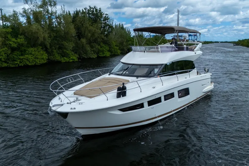 Slide: The Image of 2012 Prestige Flybridge yacht cruising on a scenic river under a partly cloudy sky. - 6