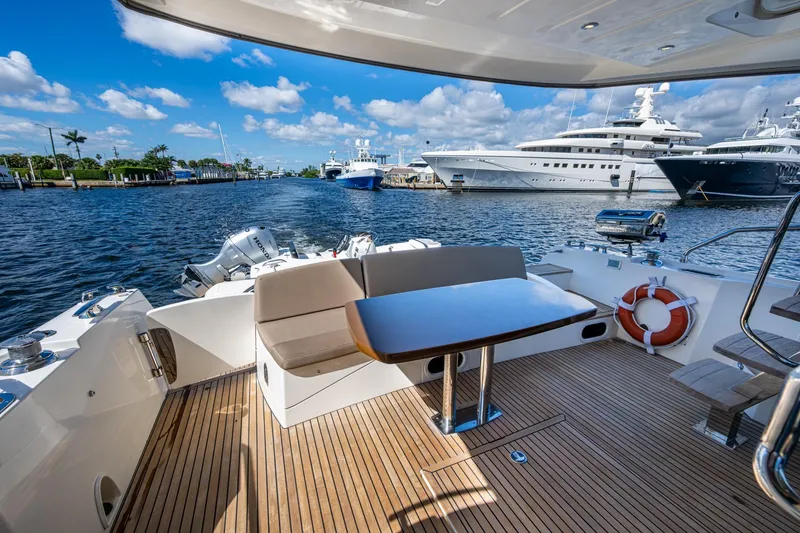 Slide: The Image of 2012 Prestige Flybridge yacht deck with seating, table, and ocean view. - 66