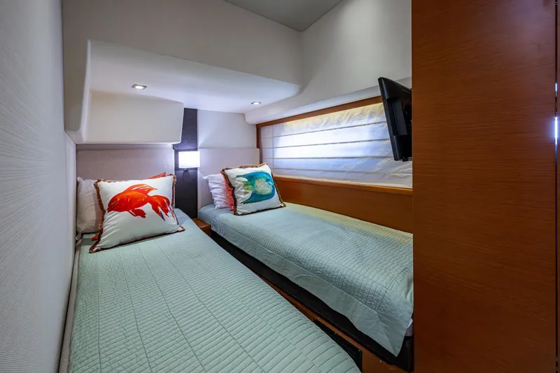Slide: The Image of 2012 Prestige Flybridge yacht cabin with twin beds and decorative pillows. - 91
