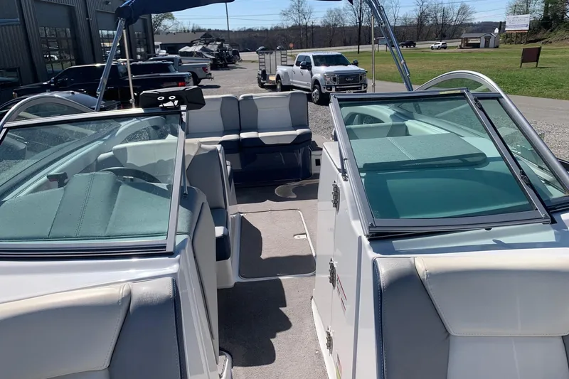 Slide: The Image of 2015 Bryant Calandra boat interior with seating and windshield, parked outdoors. - 15