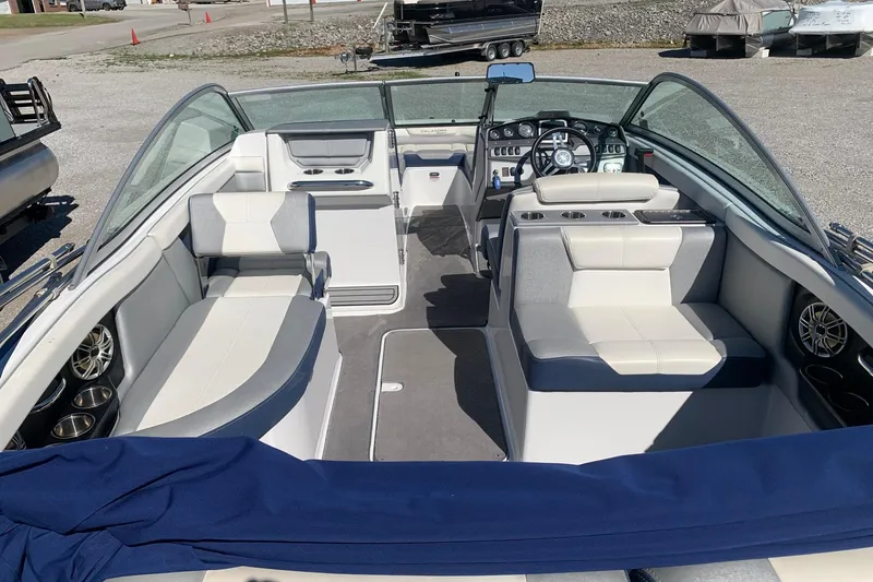 Slide: The Image of 2015 Bryant Calandra boat interior with white and gray seating, steering wheel, and cup holders. - 5