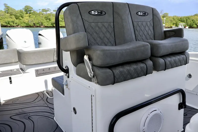 Slide: The Image of 2022 Sea Hunt Gamefish 30 Coffin Box boat seating with dual engines in scenic water setting. - 16