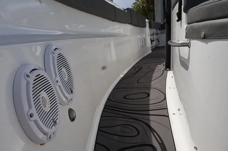 Slide: The Image of 2022 Sea Hunt Gamefish 30 Coffin Box boat interior with speakers and cushioned seating. - 28