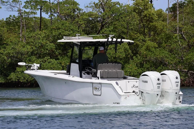Slide: The Image of 2022 Sea Hunt Gamefish 30 Coffin Box boat cruising on water with twin Yamaha engines. - 4