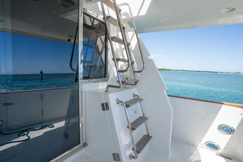 Slide: The Image of 2001 Symbol 62 Pilothouse Yacht deck with ladder and ocean view. - 12