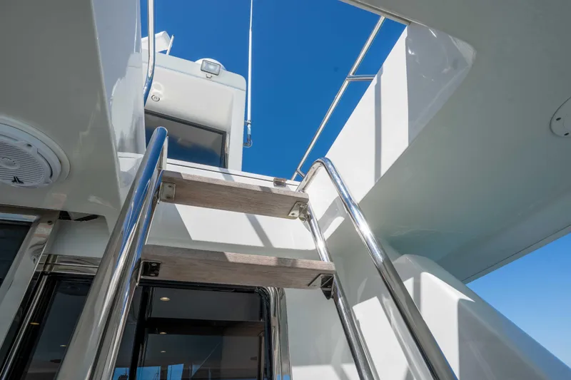 Slide: The Image of Stainless steel ladder on 2001 Symbol 62 Pilothouse Yacht under clear blue sky. - 13