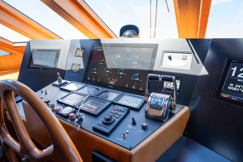 Slide: The Image of Pilothouse of 2001 Symbol 62 Yacht with modern navigation controls and wooden steering wheel. - 20
