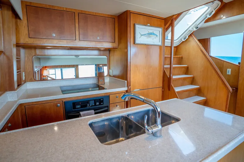 Slide: The Image of Luxurious kitchen interior of 2001 Symbol 62 Pilothouse Yacht with wooden cabinetry and modern appliances. - 24