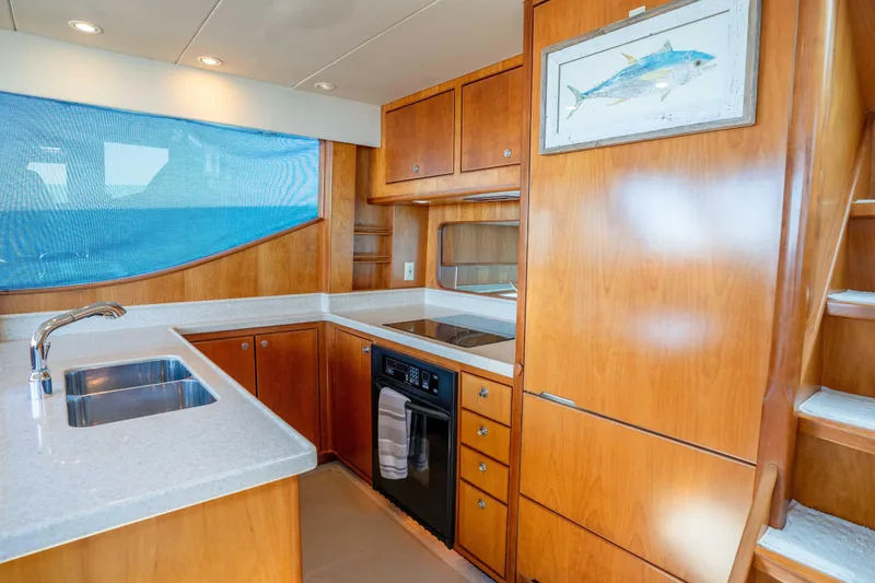 Slide: The Image of Luxurious kitchen interior of 2001 Symbol 62 Pilothouse Yacht with wood cabinetry and modern appliances. - 25