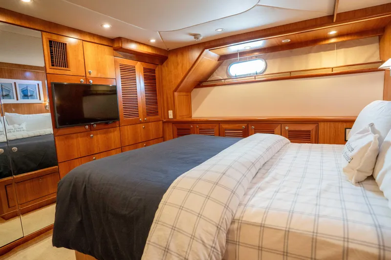 Slide: The Image of Luxurious bedroom interior of 2001 Symbol 62 Pilothouse Yacht with wood paneling and TV. - 30