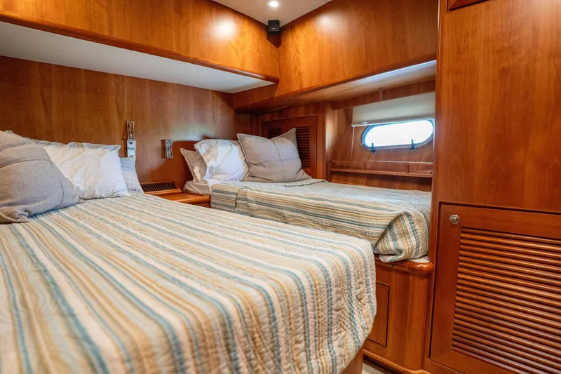 Slide: The Image of Luxurious twin cabin in 2001 Symbol 62 Pilothouse Yacht with wood paneling and cozy bedding. - 31