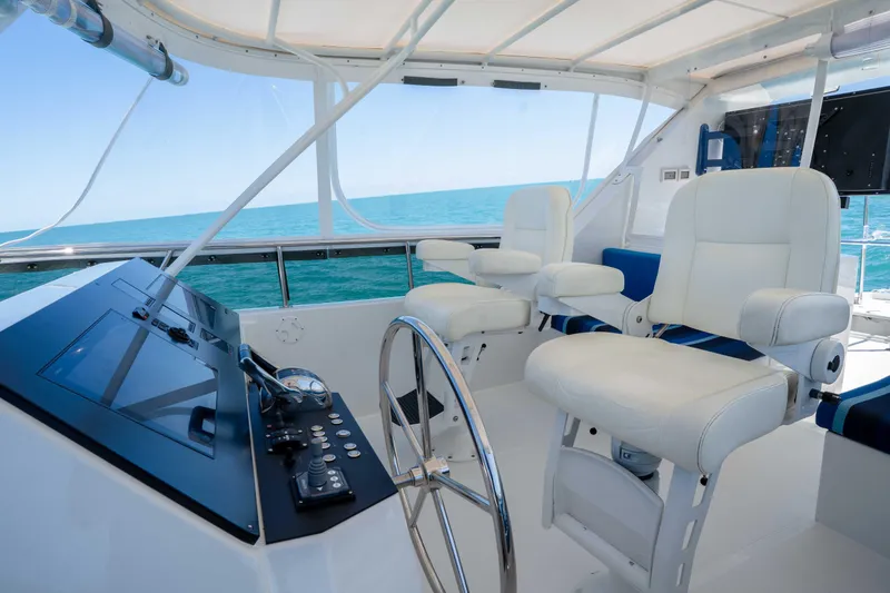 Slide: The Image of Pilothouse interior of 2001 Symbol 62 Yacht with steering wheel and white captain chairs. - 44