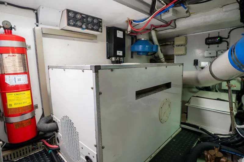 Slide: The Image of Engine room of a 2001 Symbol 62 Pilothouse Yacht with fire extinguisher and equipment. - 53