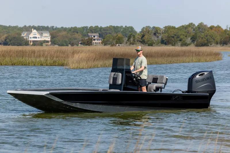 The Image of 2026 Excel 220 Bay Pro Elite boat cruising on a serene waterway with scenic background. - 0