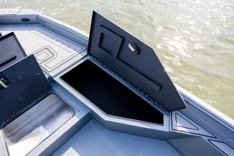 Slide: The Image of Open storage compartment on 2026 Excel 220 Bay Pro Elite boat, near water. - 12