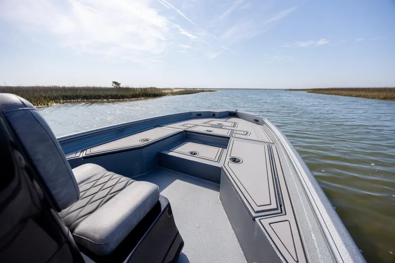 Slide: The Image of 2026 Excel 220 Bay Pro Elite boat navigating through calm waters under a clear sky. - 16