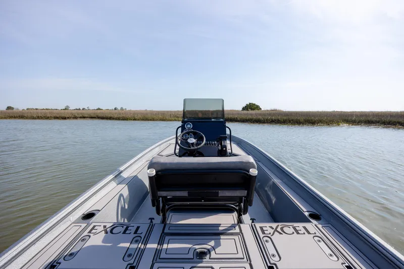 Slide: The Image of 2026 Excel 220 Bay Pro Elite boat on calm water, showcasing sleek design and spacious deck. - 22