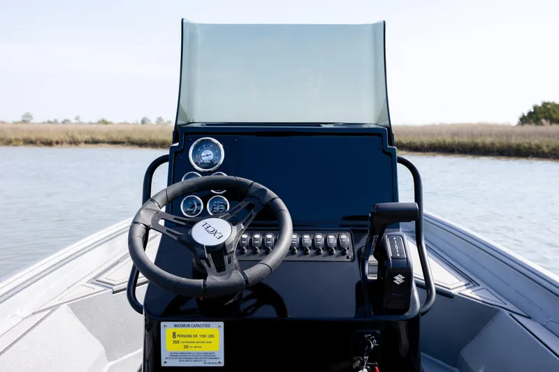 Slide: The Image of 2026 Excel 220 Bay Pro Elite boat dashboard with steering wheel and controls. - 24