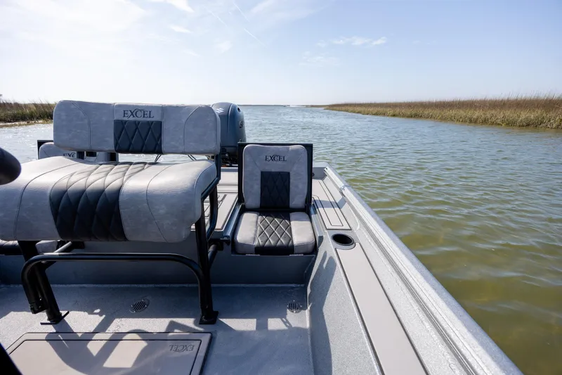 Slide: The Image of 2026 Excel 220 Bay Pro Elite boat on calm water, featuring comfortable seating. - 27
