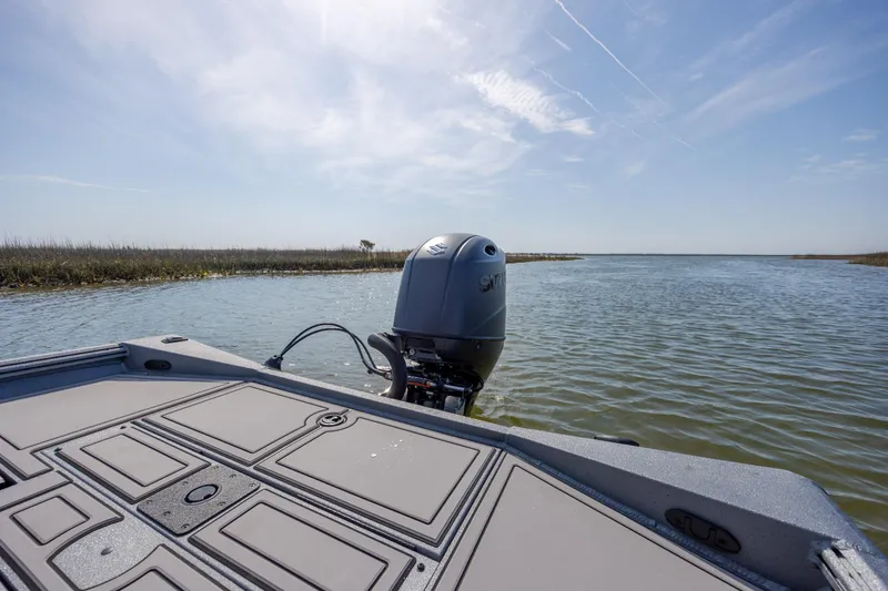 Slide: The Image of 2026 Excel 220 Bay Pro Elite boat on calm water under clear sky. - 29