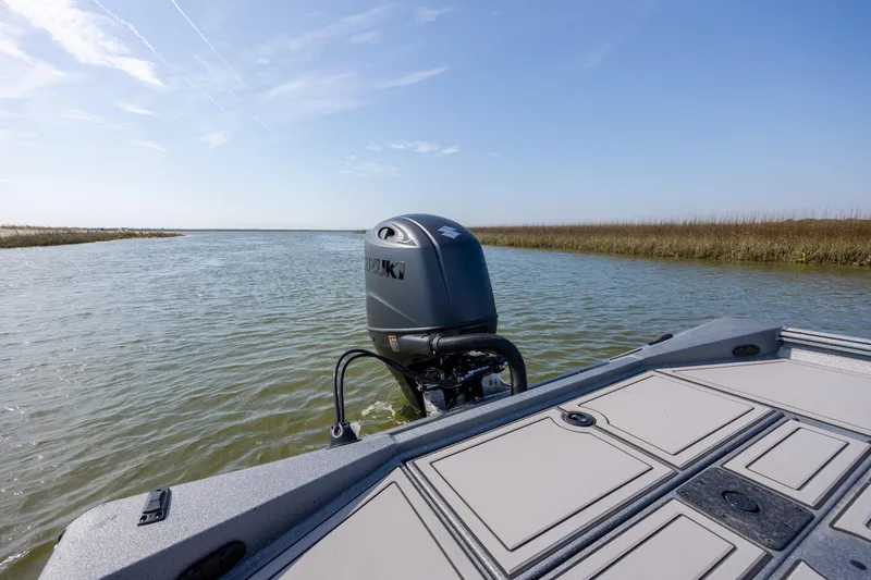 Slide: The Image of 2026 Excel 220 Bay Pro Elite boat on calm water with Suzuki outboard motor. - 30