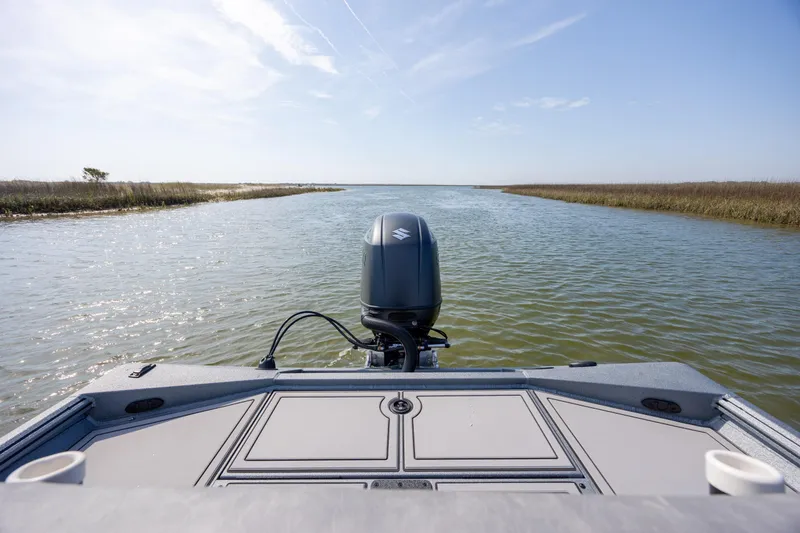 Slide: The Image of Excel 220 Bay Pro Elite 2026 boat navigating a serene waterway under a clear sky. - 31