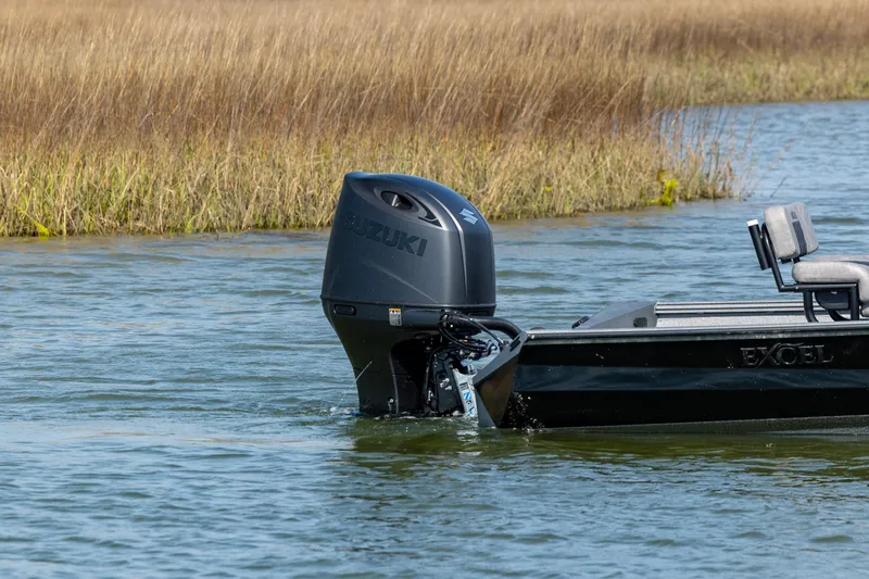 Slide: The Image of 2026 Excel 220 Bay Pro Elite boat with Suzuki outboard motor on calm water. - 4