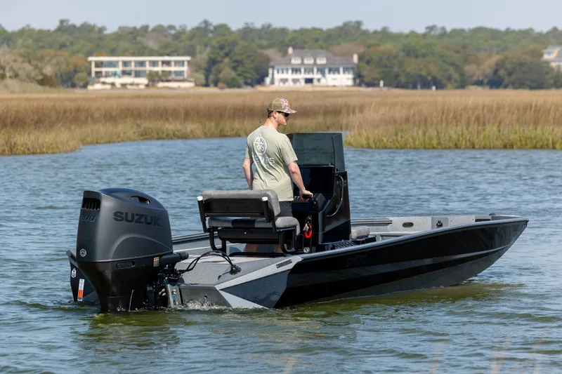 Slide: The Image of Man operating 2026 Excel 220 Bay Pro Elite boat on calm water. - 5