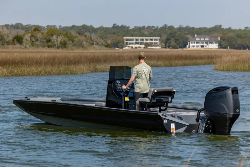 Slide: The Image of 2026 Excel 220 Bay Pro Elite boat on water with Suzuki outboard motor. - 7