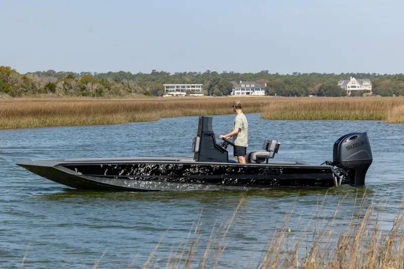 Slide: The Image of 2026 Excel 220 Bay Pro Elite boat cruising on a scenic waterway. - 8