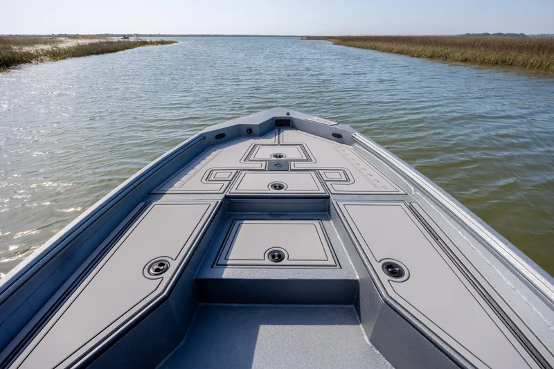 Slide: The Image of Bow view of 2026 Excel 220 Bay Pro Elite boat on calm water. - 9