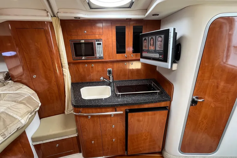 Slide: The Image of 2008 Four Winns 338 Vista yacht interior with kitchenette, microwave, and TV. - 16