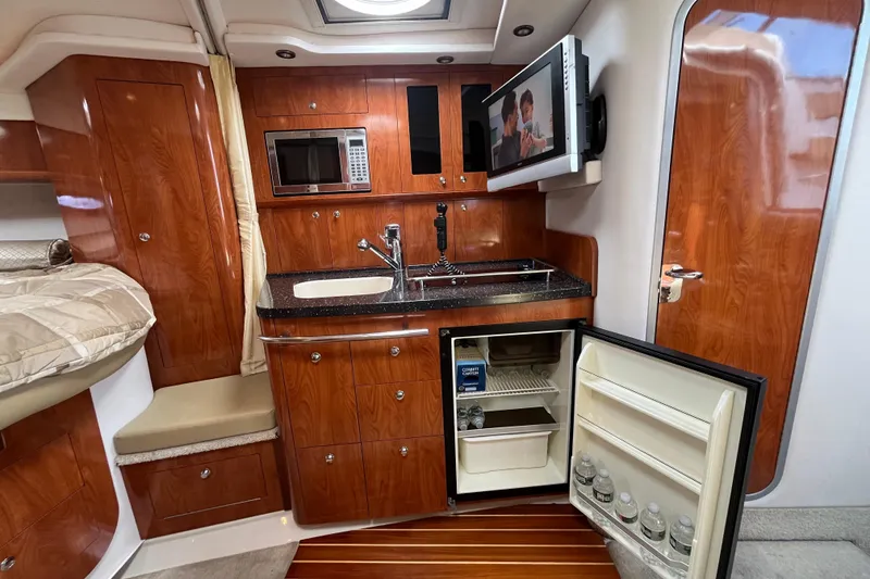 Slide: The Image of Luxurious 2008 Four Winns 338 Vista yacht interior with kitchenette, TV, and mini-fridge. - 17