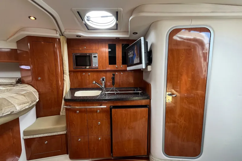 Slide: The Image of 2008 Four Winns 338 Vista cabin interior with kitchenette, wood cabinetry, and modern amenities. - 21