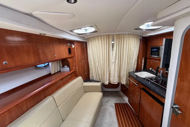 Slide: The Image of Luxurious interior of 2008 Four Winns 338 Vista yacht with wood finish and kitchenette. - 26