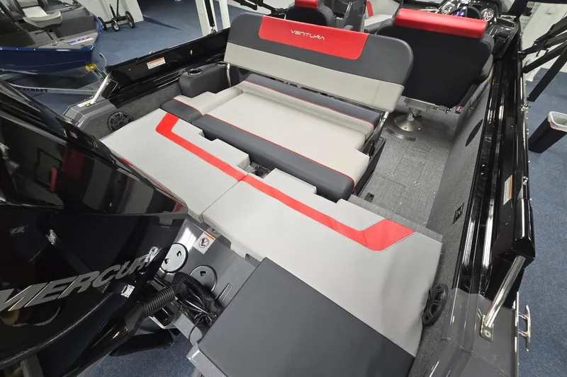 Slide: The Image of 2026 Princecraft Ventura 230 WRL boat interior with red and gray seating, featuring a Mercury engine. - 20
