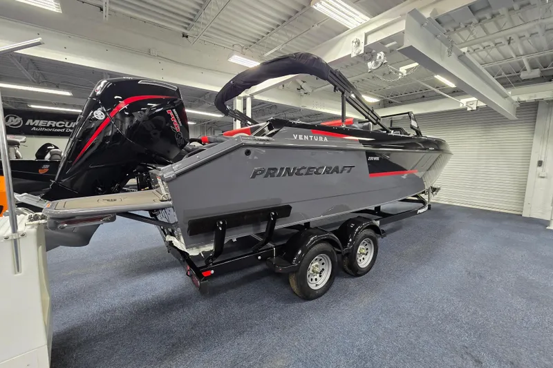 Slide: The Image of 2026 Princecraft Ventura 230 WRL boat on trailer in showroom, featuring sleek design and powerful engine. - 21