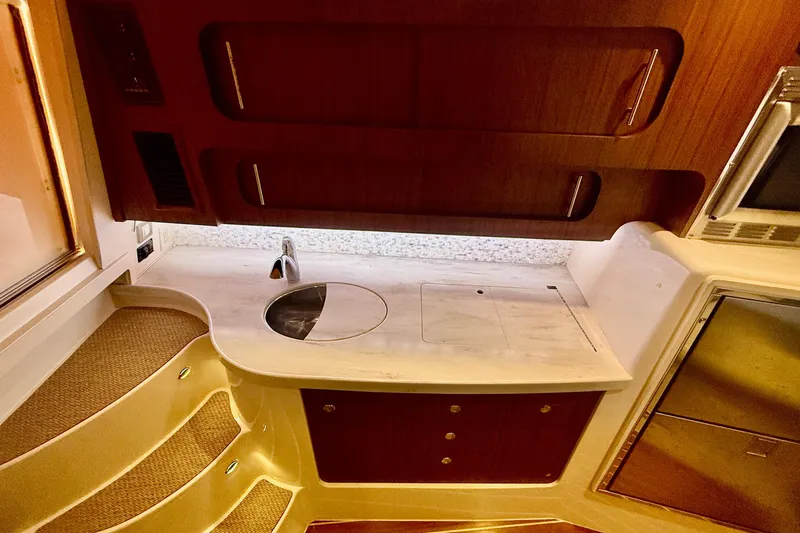 Slide: The Image of 2015 Grady-White Express 370 interior with compact kitchen and wooden cabinetry. - 24