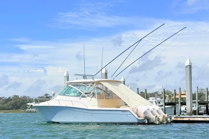 Slide: The Image of 2015 Grady-White Express 370 boat docked with fishing rods, under a clear blue sky. - 40
