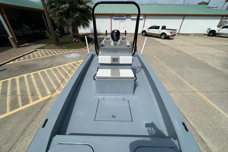 Slide: The Image of 2026 Skuta 24 Vista boat in parking lot, showcasing sleek design and spacious deck. - 17