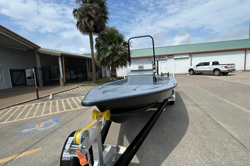 Slide: The Image of 2026 Skuta 24 Vista boat on trailer in parking lot, palm trees in background. - 2