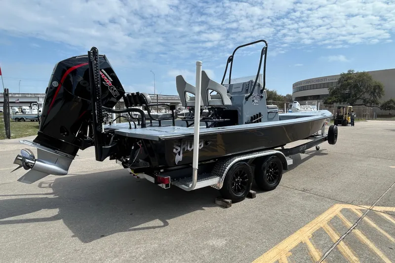 Slide: The Image of 2026 Skuta 24 Vista boat on trailer with powerful outboard motor, parked outdoors. - 5