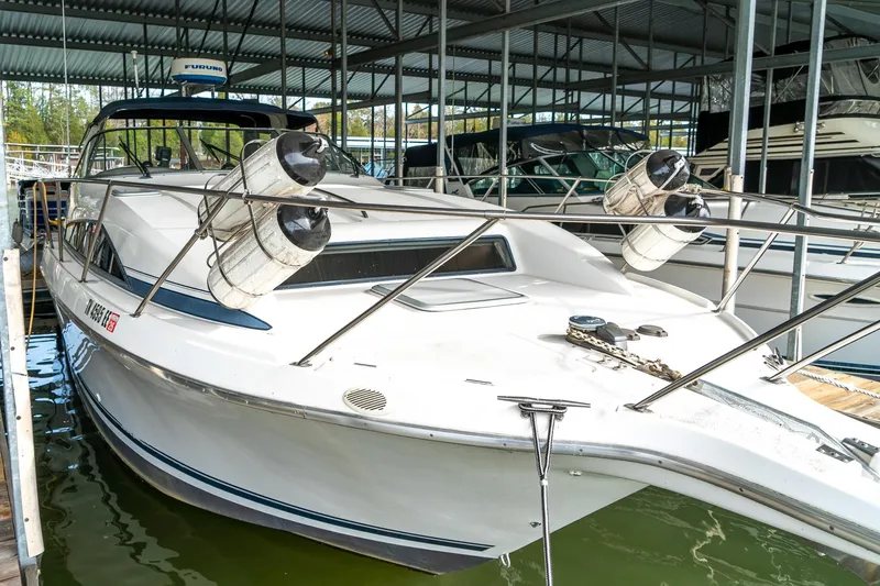 Slide: The Image of 1998 Bayliner 3255 Avanti docked in a marina, featuring sleek design and fenders. - 1