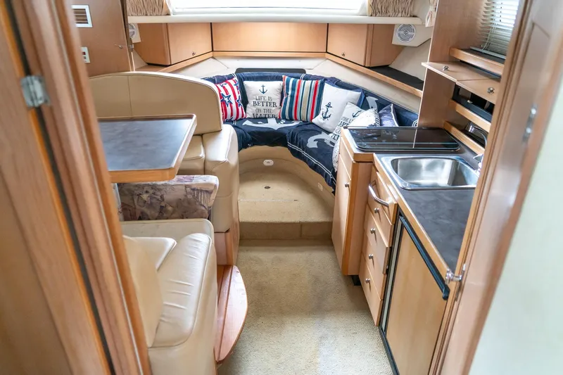 Slide: The Image of Interior of 1998 Bayliner 3255 Avanti boat with cozy seating and compact kitchen area. - 12