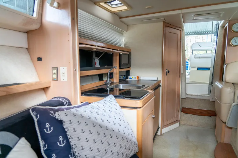 Slide: The Image of Interior of 1998 Bayliner 3255 Avanti boat with kitchenette and seating area. - 14
