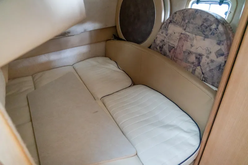 Slide: The Image of Interior cabin of a 1998 Bayliner 3255 Avanti boat, featuring cushioned seating. - 16