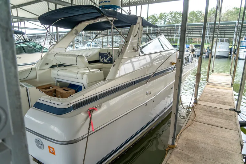 Slide: The Image of 1998 Bayliner 3255 Avanti docked in a marina, featuring a sleek white design. - 2