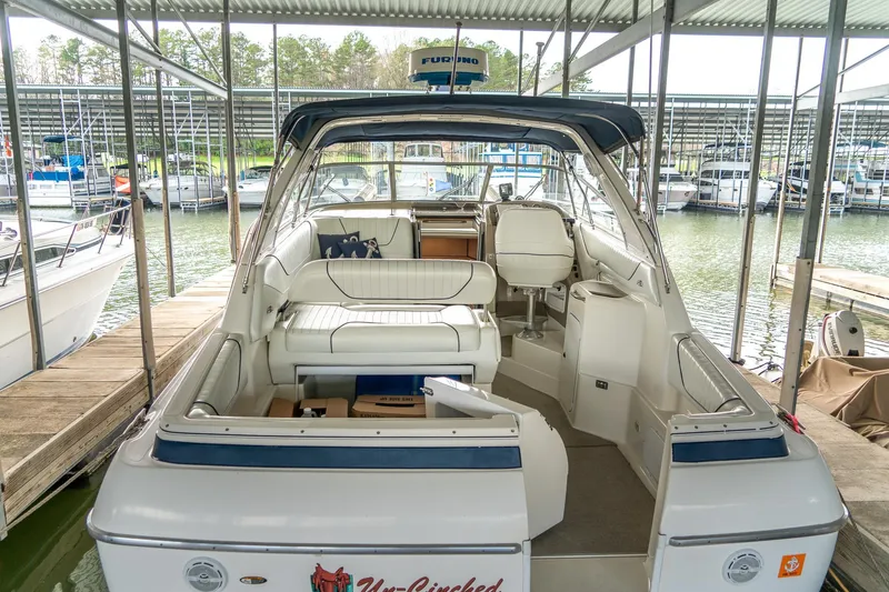 Slide: The Image of 1998 Bayliner 3255 Avanti boat interior at marina dock, featuring seating and helm. - 4