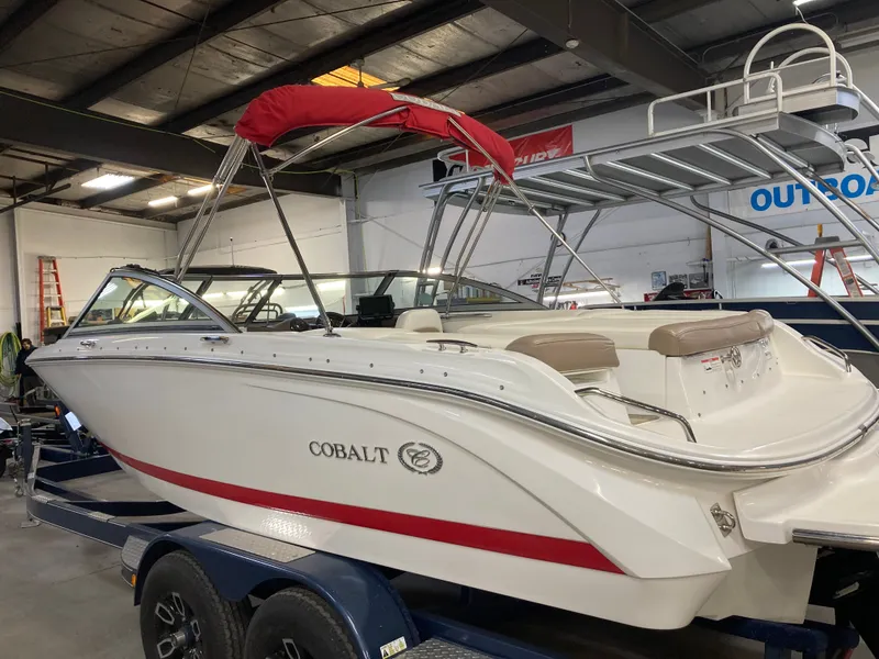 Slide: The Image of 2013 Cobalt 200 boat with red canopy in a warehouse setting. - 4